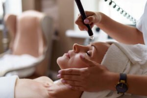 Woman receives relaxing facial with advanced skincare technology in a tranquil spa setting.