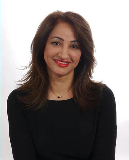 Confident Woman With A Warm Smile, Elegant Black Top, Flowing Hair, And Bold Red Lips.