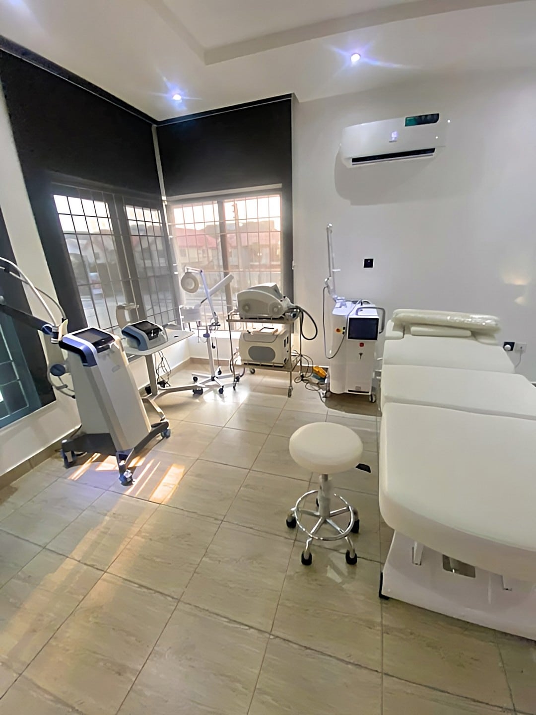 Modern Cosmetic Treatment Room With Skincare Equipment, Bright Lighting, And A Comfortable Treatment Bed.
