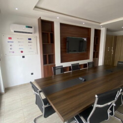 Modern Conference Room Featuring A Wooden Table, Ergonomic Chairs, Tv, Whiteboard, And Advanced Tech For Productive Meetings. Modern Conference Room With Wooden Table, Ergonomic Chairs, Tv, Whiteboard, And Advanced Tech Amenities.