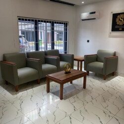 Elegant Modern Living Room With Green Armchairs, Marble Floors, Natural Light, And Minimalist Decor For Stylish Relaxation. Modern Living Room With Green Armchairs, Marble Floors, Natural Light, And Stylish Minimalist Decor.