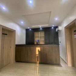 Modern Minimalist Reception With A Sleek Wooden Desk, Bright Lighting, And Contemporary Design For A Professional, Welcoming Atmosphere. Modern Minimalist Reception Area With Sleek Wood Desk, Bright Lighting, And Contemporary Design.