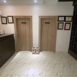 Elegant Modern Reception With Wooden Doors, Marble Floors, Minimalist Desk, And Warm Ambient Lighting Creating A Welcoming Professional Atmosphere. Modern Reception With Wooden Doors, Marble Flooring, Minimalist Desk, And Warm Ambient Lighting.