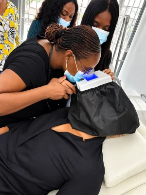 Dermatologist examining a client's skin with a device.