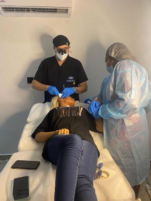 Medical Professionals Performing Cosmetic Treatment In Clinic Cosmetic Treatment In Clinic With Healthcare Professionals Ensuring Safety And Comfort During Procedure.